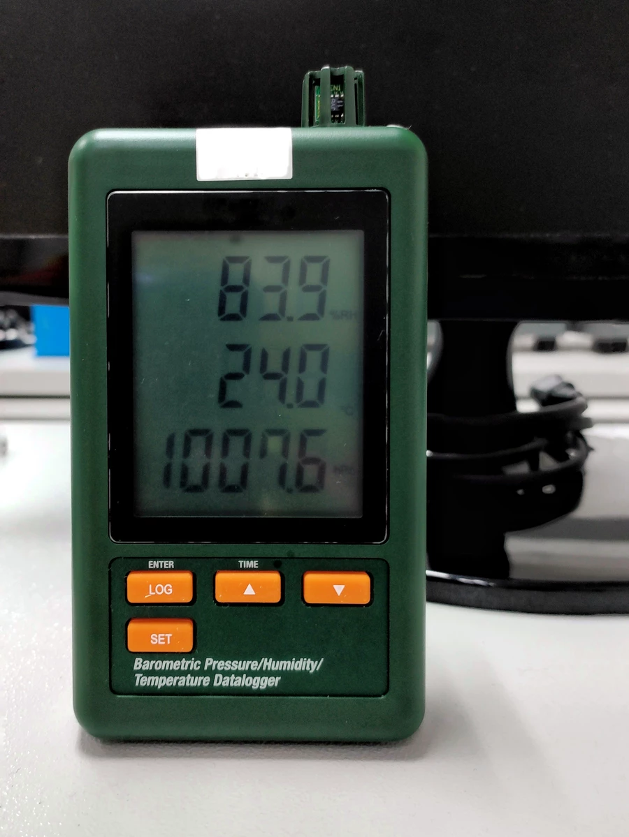 A pressure, humidity, and temperature data logger on someone’s desk.